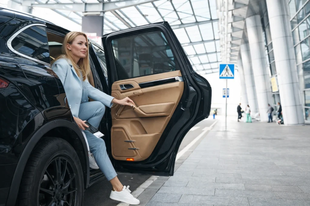 Service VTC haut de gamme avec passagère arrivant dans un terminal